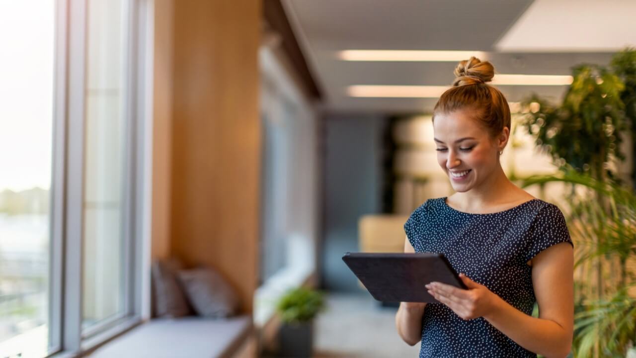 Woman examining IoT cyber security software via tablet.